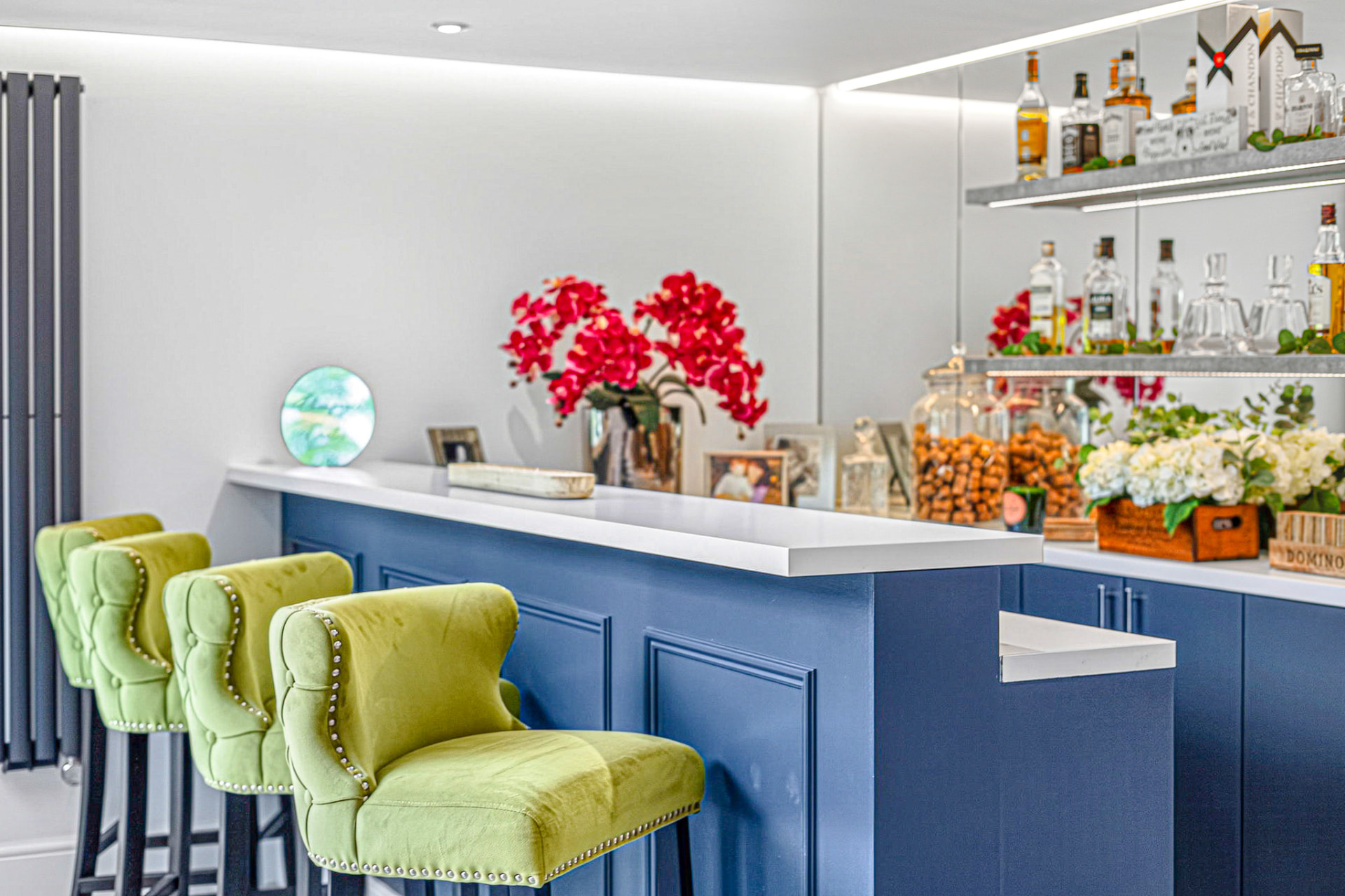 Home bar with velvet stools and navy cabinetry photographed in HDR